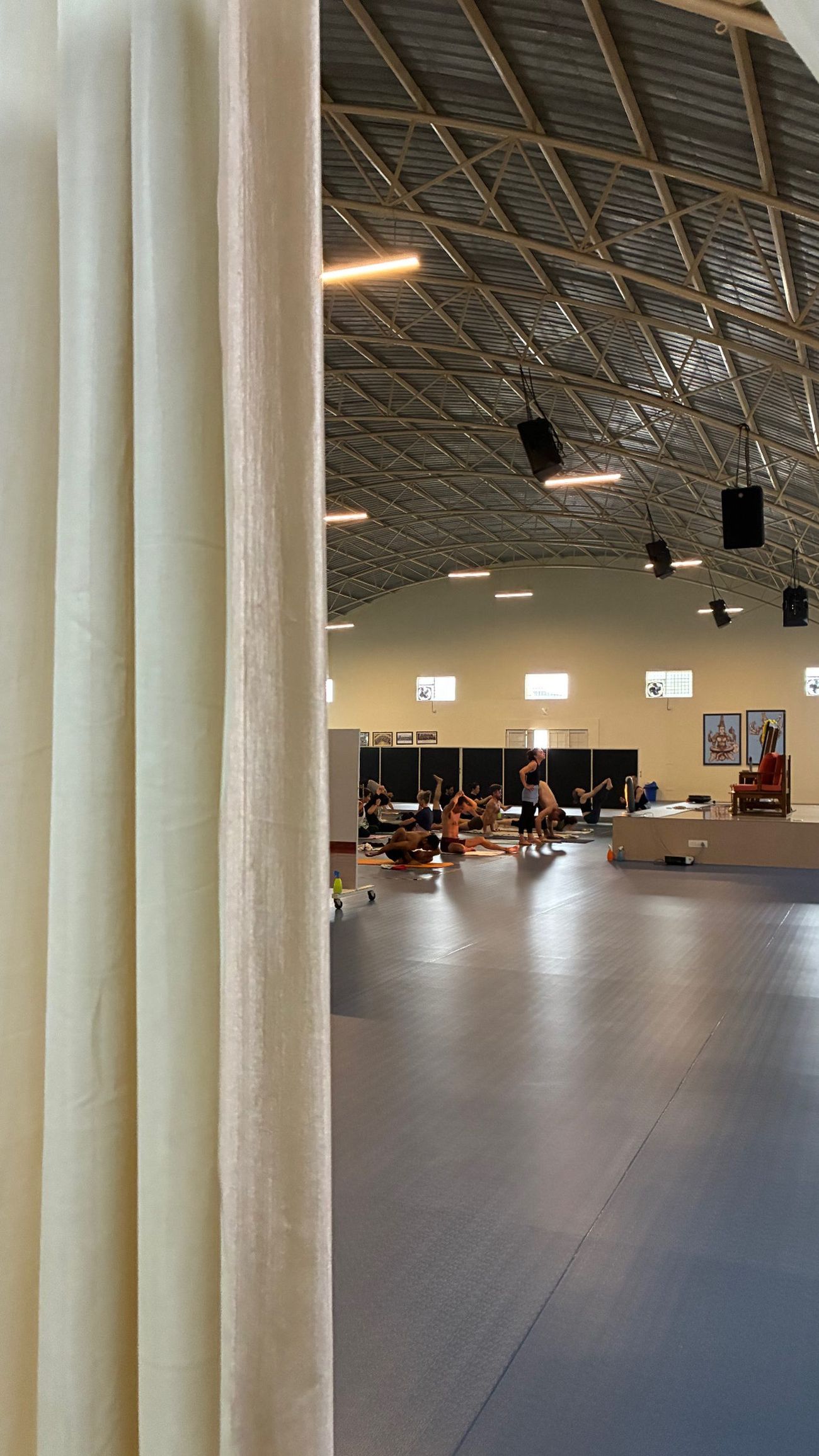 Students practicing Mysore-style in the main hall at the Sharath Yoga Centre
