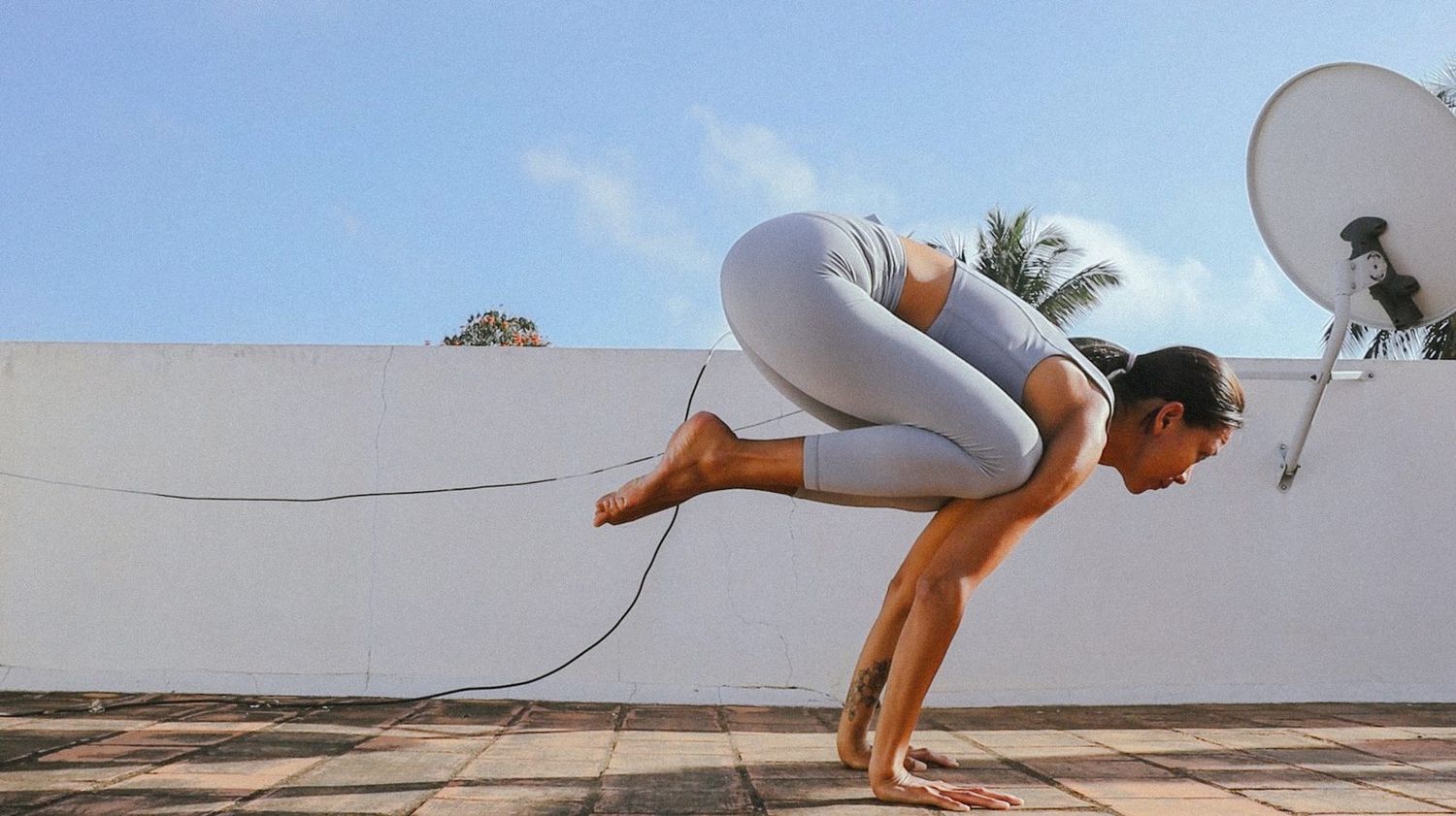 Meow in Bakasana on a Hua Hin rooftop